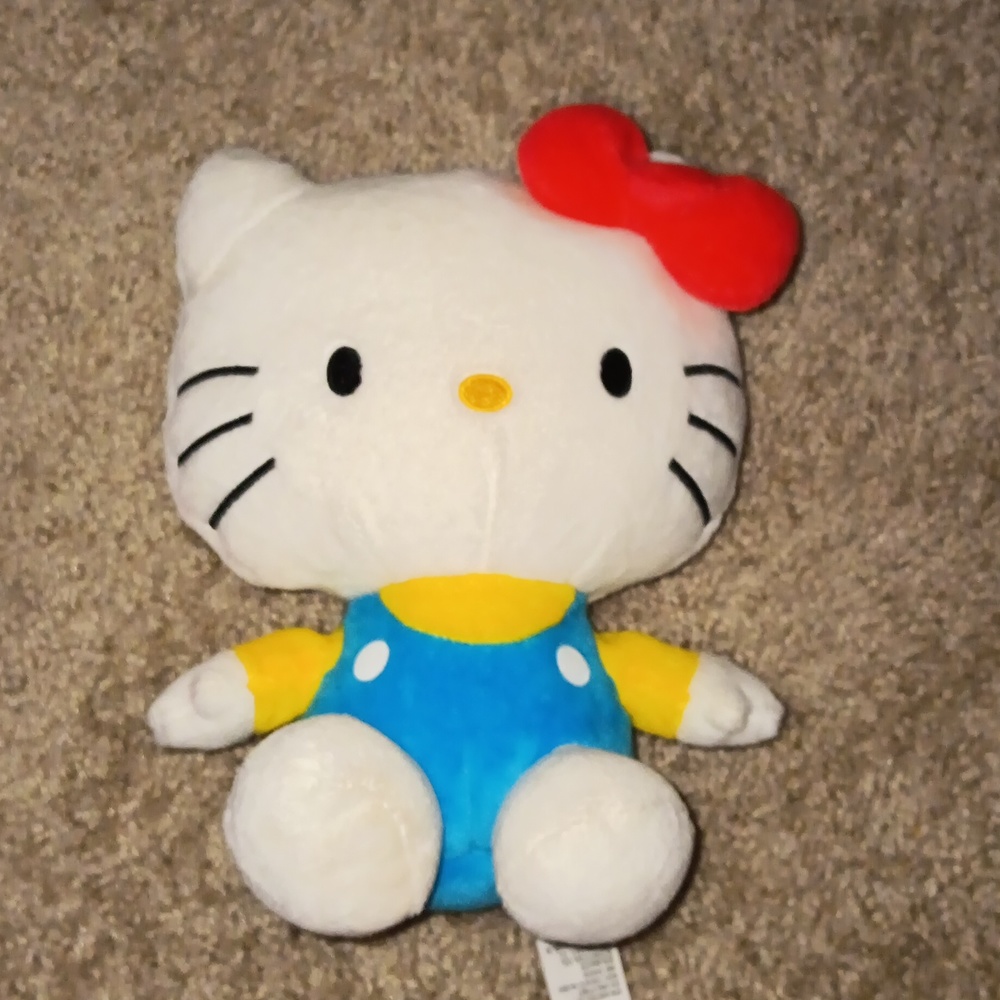 Hello Kitty With Blue Overalls and a yellow shirt.